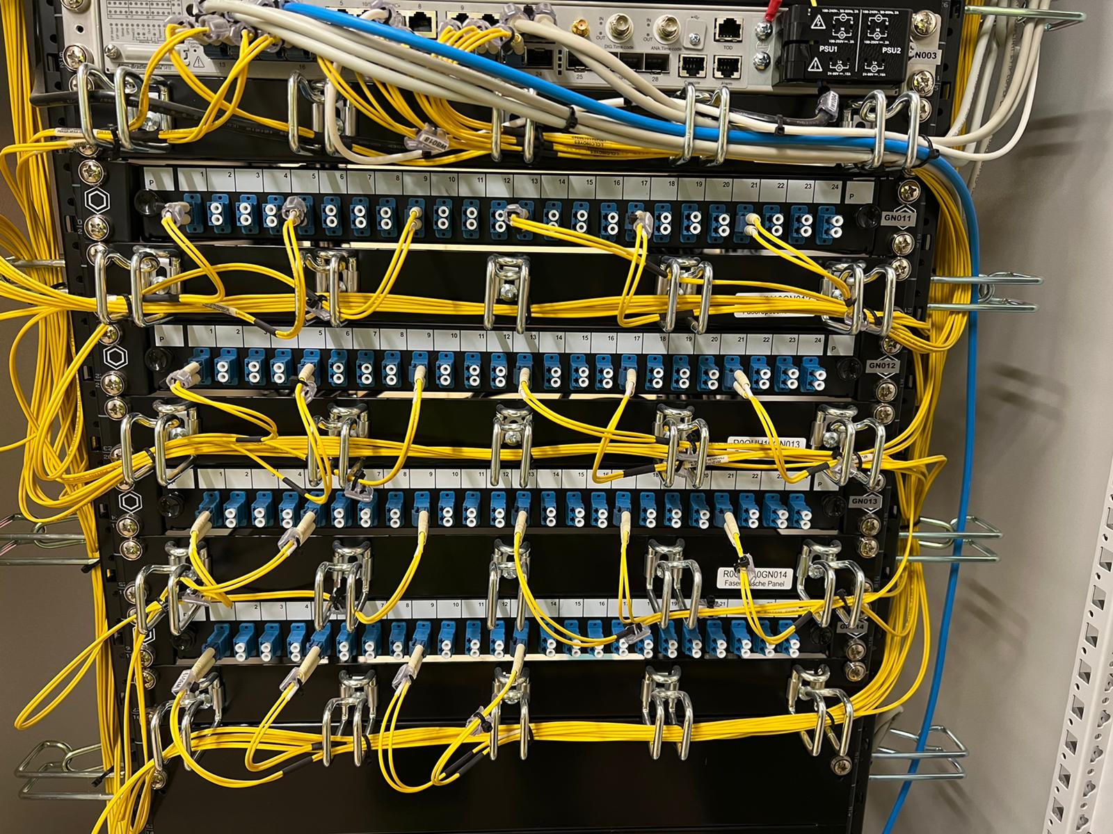 Pannelli ottici attestati, porte numerate e bretelle organizzate nel rack.
