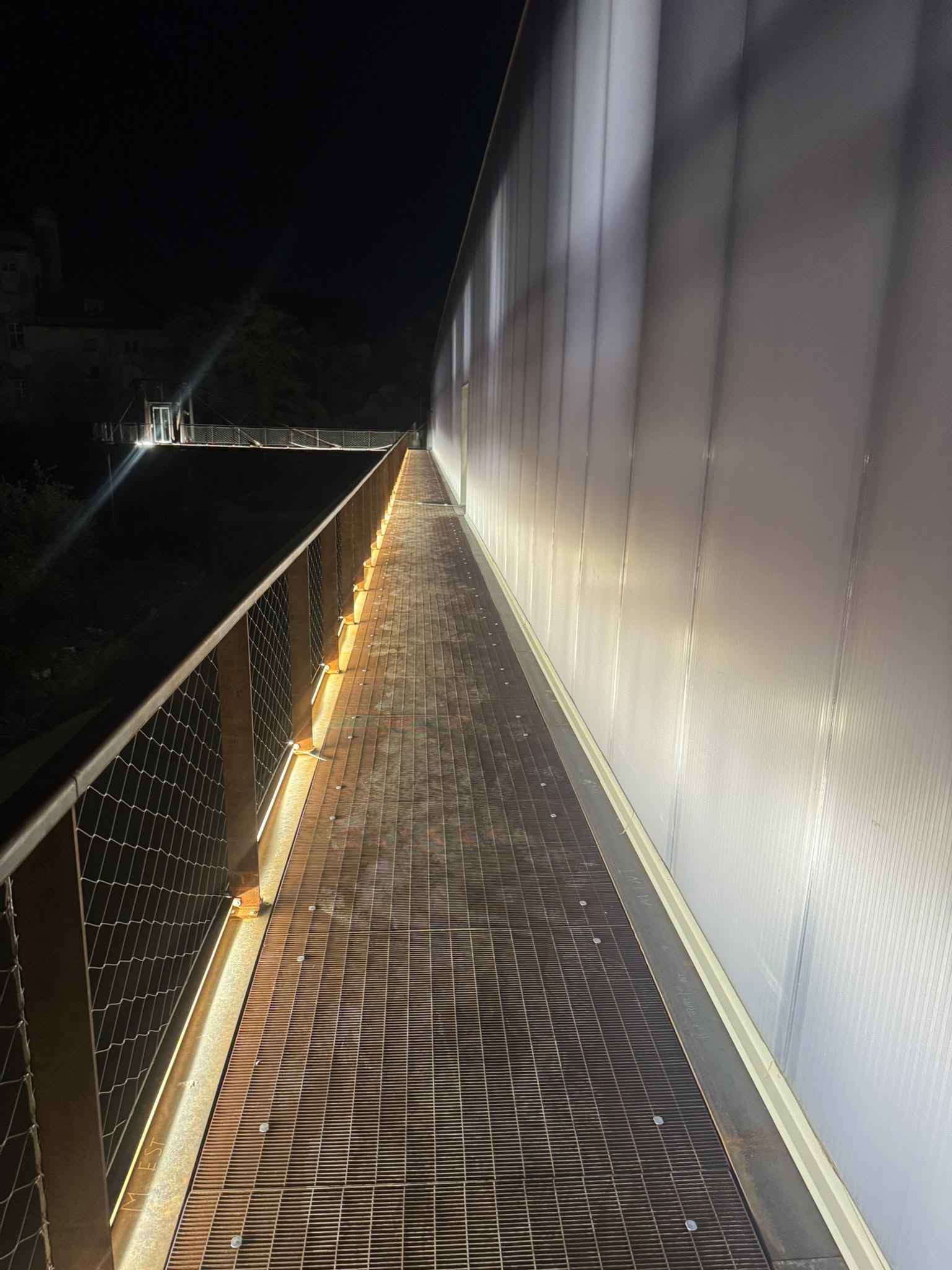 Illuminazione lineare lungo la passerella adiacente alla struttura del parco.