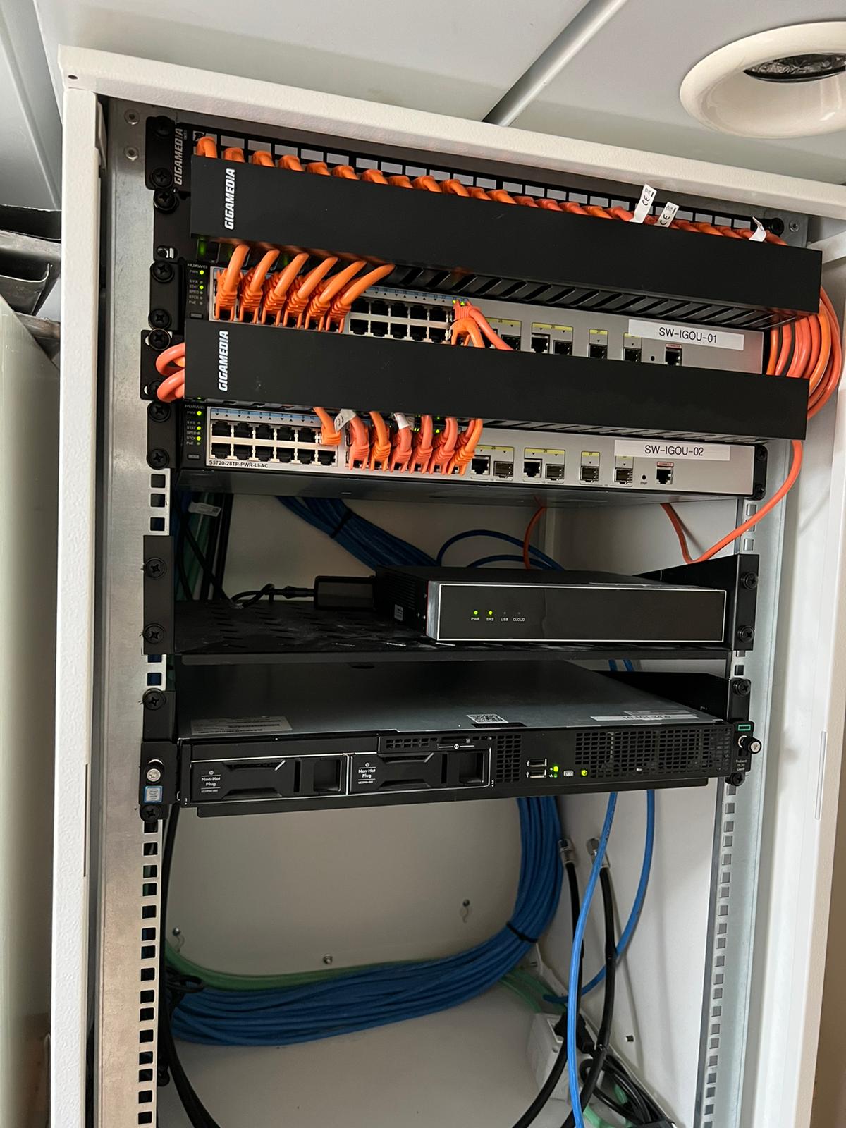 Armadio di rete con switch, pannelli di connessione e apparati.